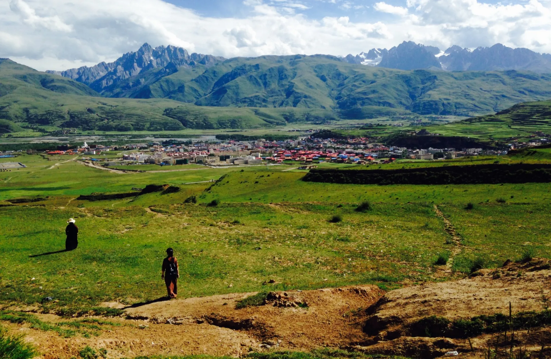 Two women walking toward mountains